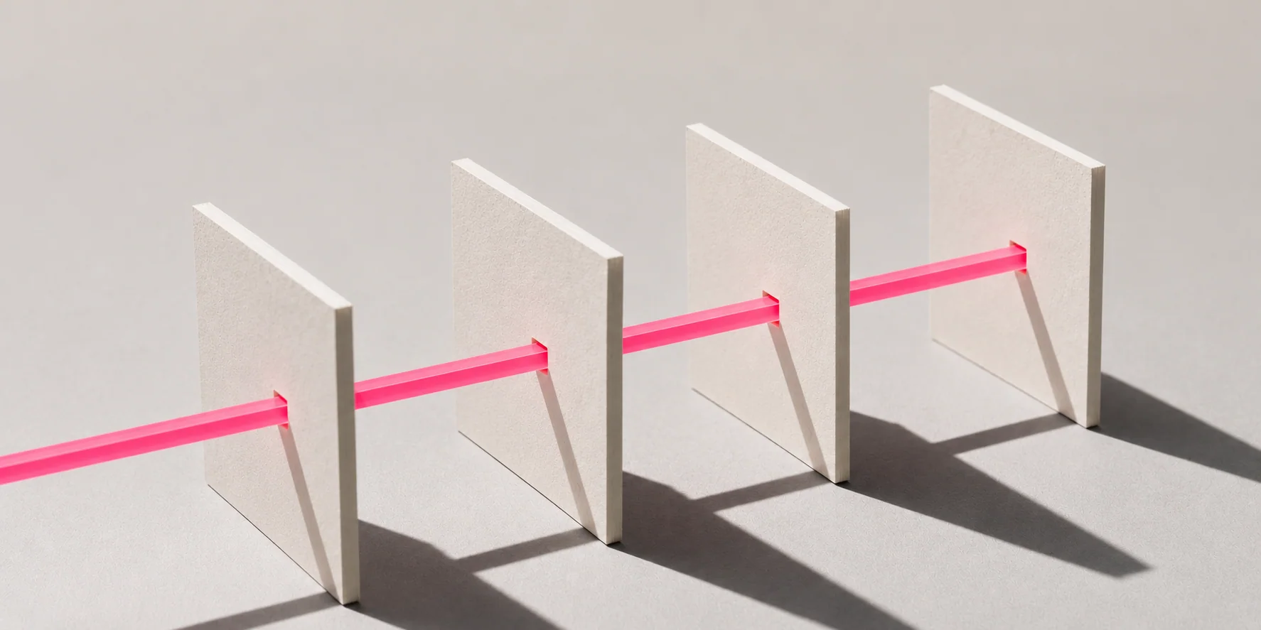 Panneaux blancs traversés par un faisceau rose, évoquant la structure et le parcours d'un site internet sur mesure